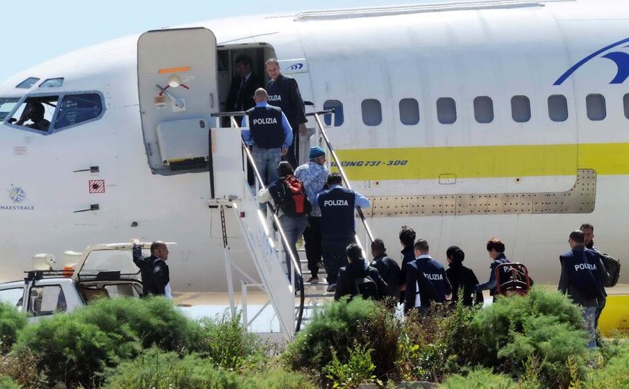 polizia scorta dei migranti su un volo per il rimpatrio (foto ansa)