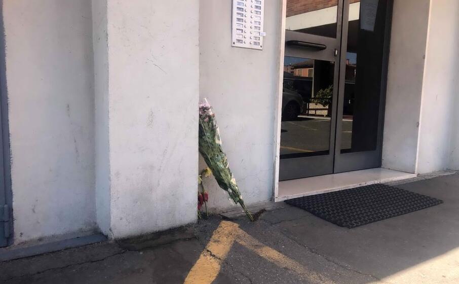 fiori accanto al portone del palazzo (ansa)