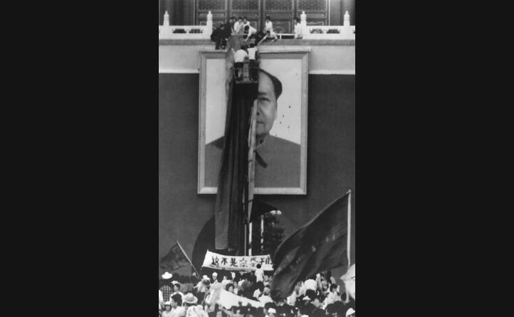 un drappo rosso a coprire il ritratto di mao