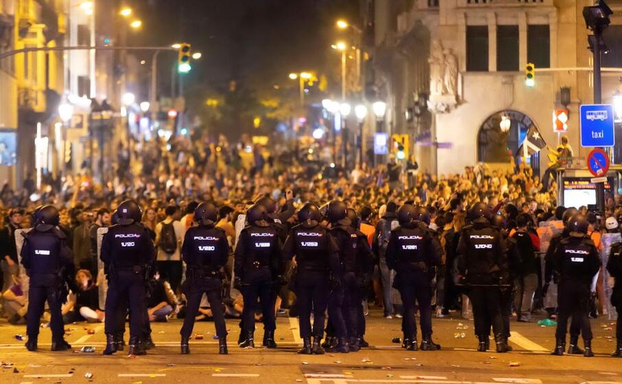 la polizia fronteggia i manifestanti a barcellona (ansa)