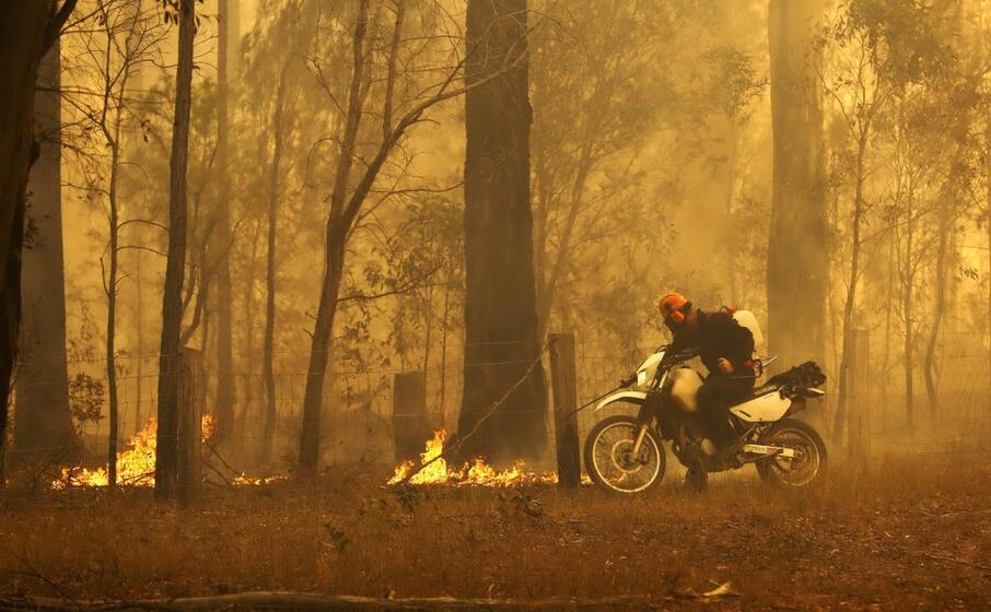 un cittadino tenta di spegnere le fiamme (ansa)
