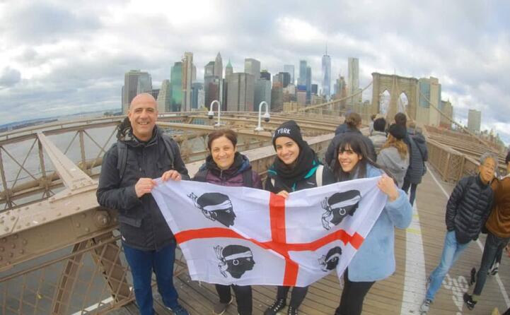 la famiglia zuddas (pa gianfranco mamma giuseppina con ilaria e giulia) da bonacardo in posa sul ponte di brooklyn con lo skyline di new york alle spalle