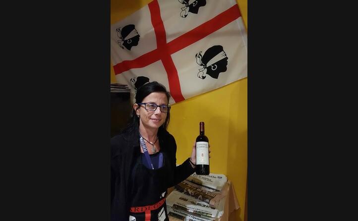 marinella mura a losone al ristorante su pastori con bandiera sarda e bottiglia di cannonau