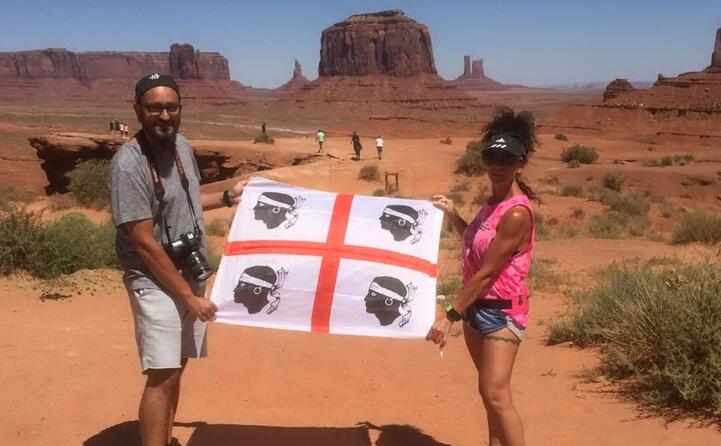 ylenia e diego in posa con la bandiera sarda alla monument valley negli usa