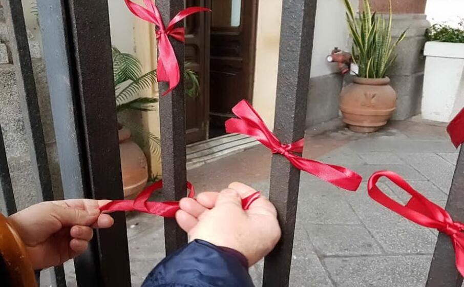 i nastrini rossi di solidariet all ingresso di palazzo civico in via roma a cagliari (foto comune di cagliari)