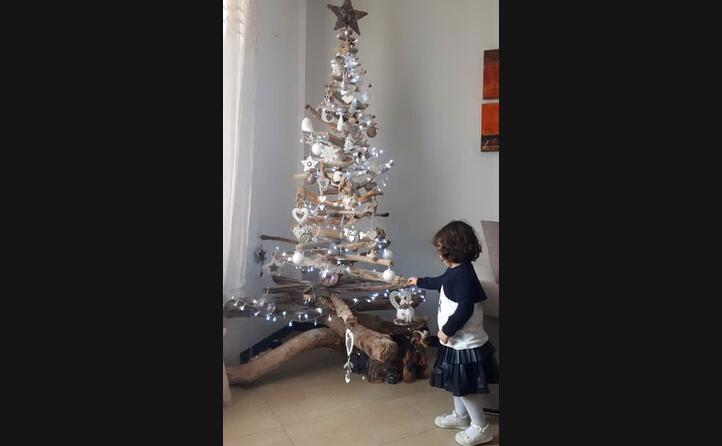 la piccola viola davanti all albero plastic free realizzato con rami trovati sulla spiaggia e decorazioni di legno e stoffa fatto da sara livretti da sant antioco
