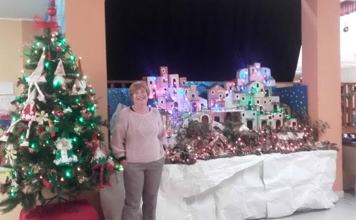 luisa muscas in posa davanti al presepe e all albero di natale della scuola primaria nanni loy di cagliari