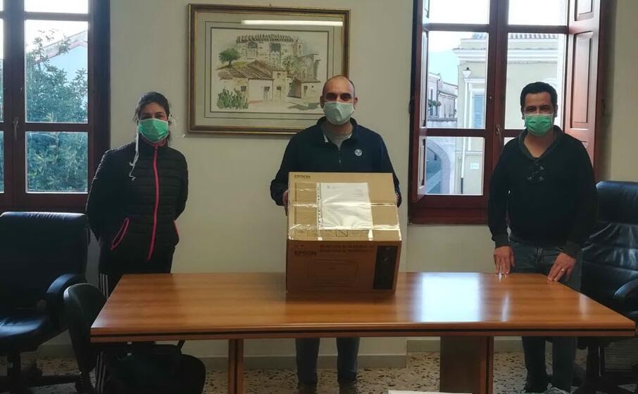 l assessore marco mandis regge il plico di mascherine ai lati gli assessori arianna porcu e francesco mameli (farris)