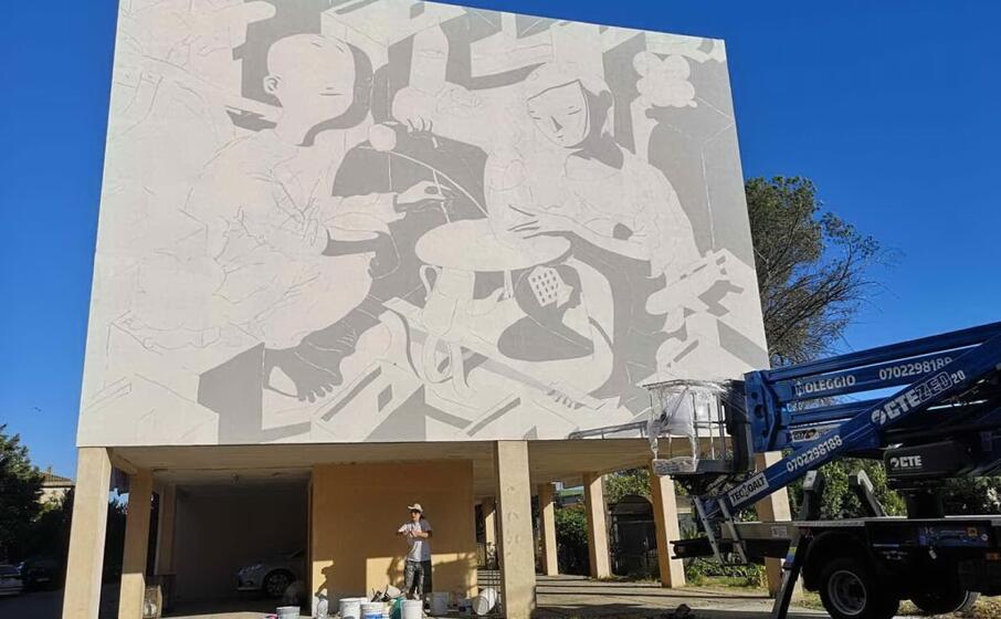 l artista millo durante la realizzazione del murale in via pascoli (foto pittau)