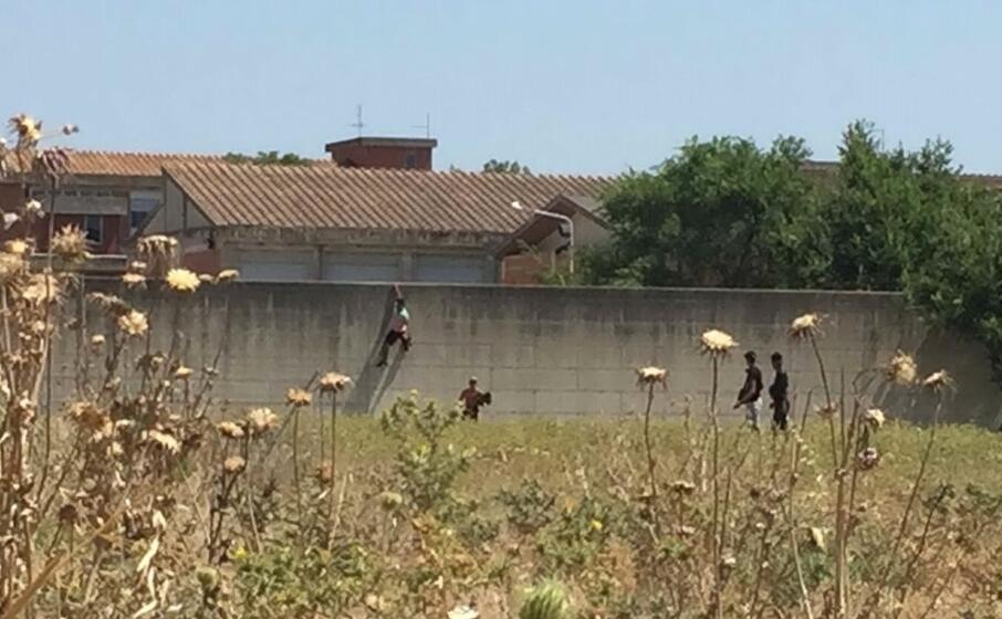 i migranti mentre scavalcano il muro (foto l unione sarda manunza)