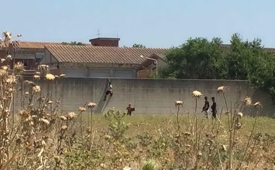 i migranti scavalcano il muro di cinta (foto l unione sarda manunza)