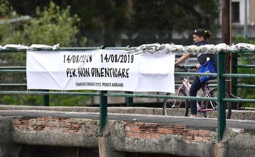 Lo striscione e le 43 rose del Comitato dei parenti delle vittime (Ansa)