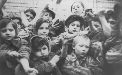Bimbi mostrano ad Auschwitz i loro numeri tatuati dopo la liberazione dei sovietici (foto via Ansa)